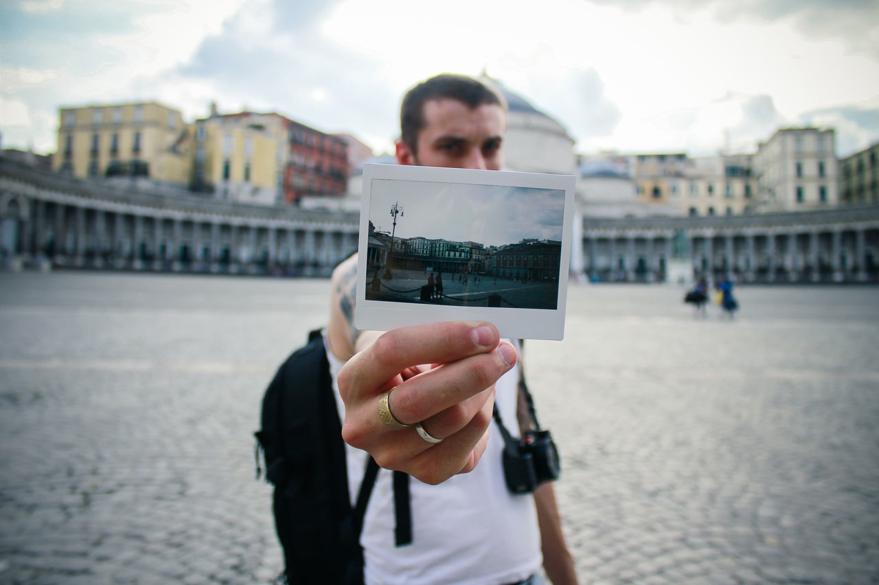 Close-up of man photograph with city in background