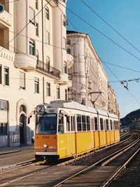 Train on railroad tracks in city against sky