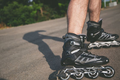 Low section of man roller skating on road