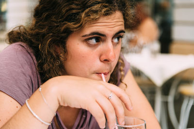 Close-up of young woman drinking at cafe