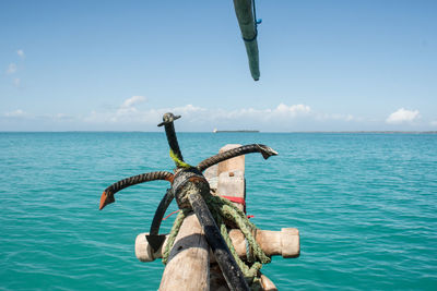 Anchor on boat in sea against blue sky during sunny day