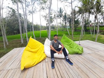 Full length of man sitting on bean bag against farm