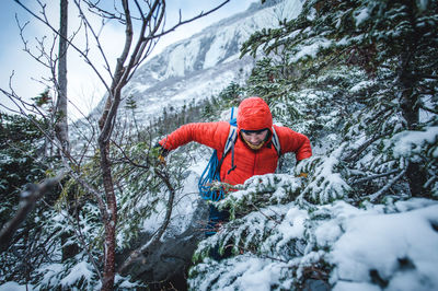 Midsection of person on snowcapped mountain during winter