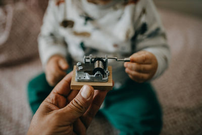 Close-up of man giving small machinery to baby