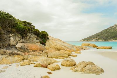 Rocks on beach against sky