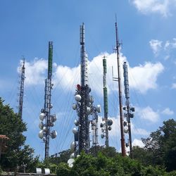 Low angle view of communications towers against blue sky