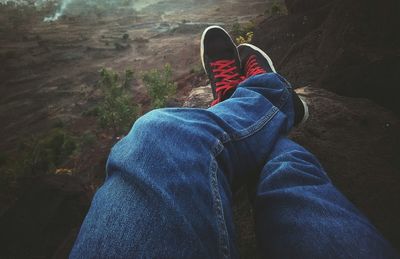 Low section of man wearing shoes on cliff