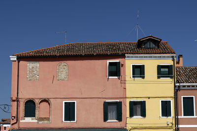 Low angle view of old building against clear blue sky