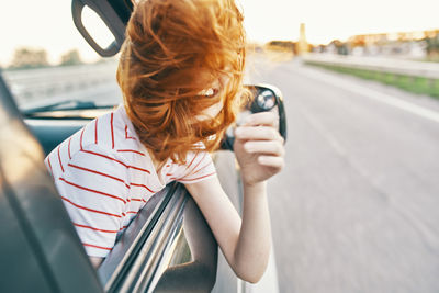 Portrait of woman photographing with mobile phone