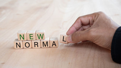 Close-up of hand holding text on table