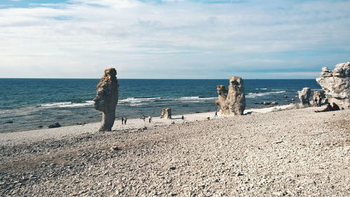 Scenic view of beach against cloudy sky