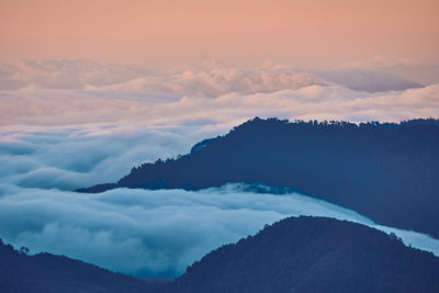 Scenic view of cloudscape against mountains during sunset