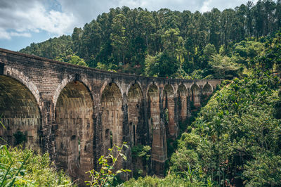 Arch bridge over river against sky