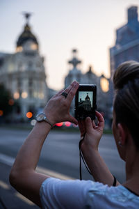 Man photographing with mobile phone in city