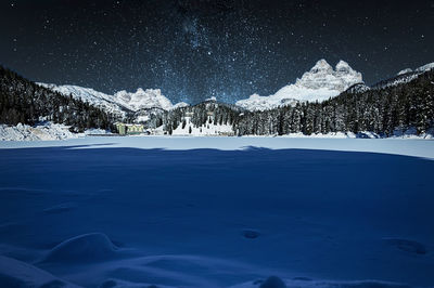 Scenic view of snowcapped mountains against sky at night