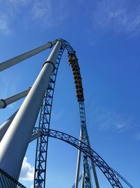 Low angle view of people enjoying rollercoaster ride against sky