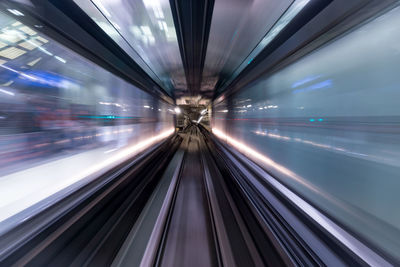Blurred motion of train at illuminated railroad station