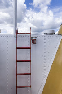 Close-up of airplane wing against cloudy sky