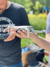 Midsection of man holding drone outdoors