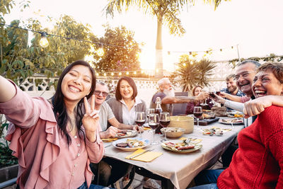 Happy friends sitting at outdoor restaurant