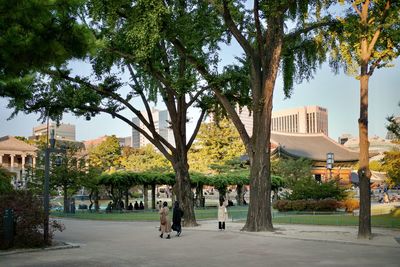 People walking on street amidst buildings in city