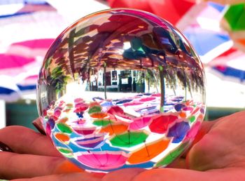 Close-up of person holding multi colored glass
