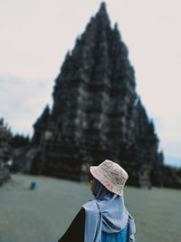 Rear view woman standing against temple