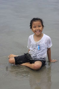 Portrait of young woman sitting at beach