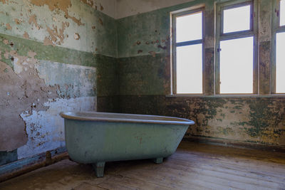 Bath and broken window in abandoned room