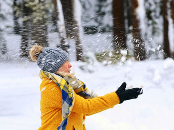 Full length of child on snow covered tree during winter