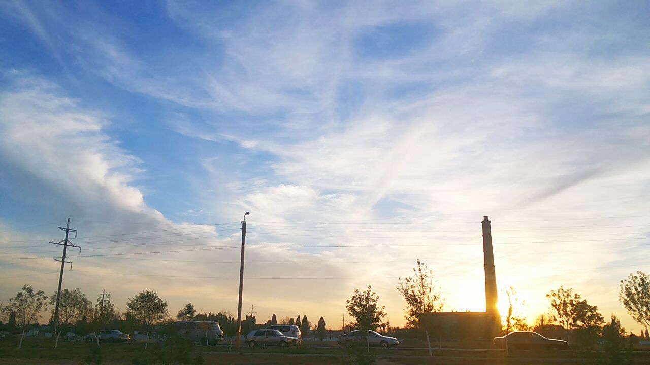 sky, sunset, street light, cloud - sky, tree, silhouette, car, cloud, sun, nature, tranquility, beauty in nature, scenics, cloudy, transportation, tranquil scene, low angle view, land vehicle, sunlight, no people