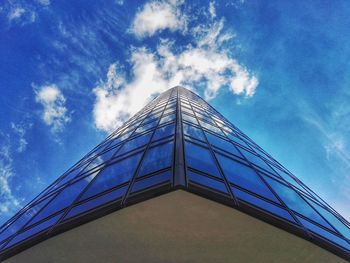 Low angle view of skyscraper against blue sky