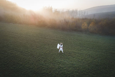 Man standing on field during foggy weather