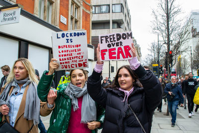 Young women standing on street in city