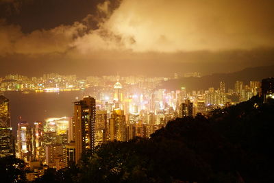 Illuminated buildings in city against sky at night