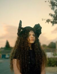 Portrait of young woman against sky