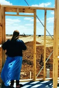 Rear view of woman standing against sky