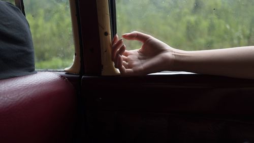 Close-up of hand on window