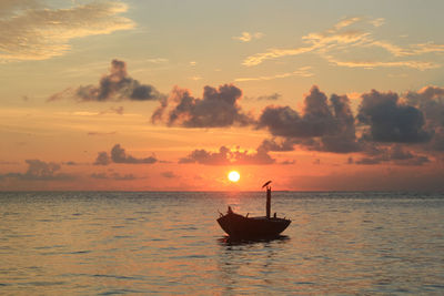 Silhouette boat in sea against sky during sunset