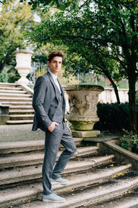 Portrait of young man standing on staircase