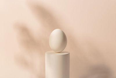 One white easter egg on a podium against a neutral background. minimalism and simplicity aesthetics