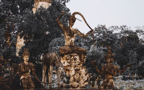 Low angle view of statue against trees