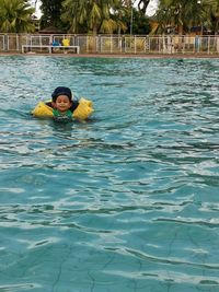 Portrait of smiling man swimming in pool