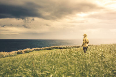 Woman standing amidst plants during sunset