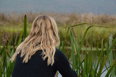 Rear view of young woman standing on field