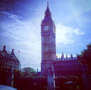 Low angle view of clock tower against cloudy sky