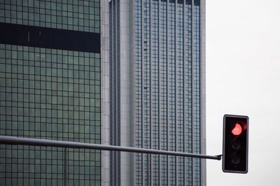 Close-up of illuminated road sign against sky in city