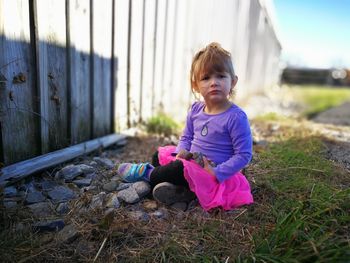 Portrait of cute girl sitting on field