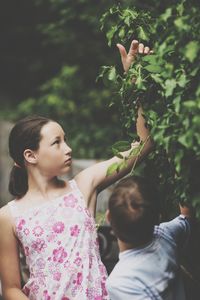 Woman standing against plants and trees