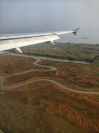 Airplane flying over landscape against the sky